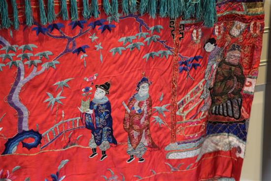 A Chinese embroidered silk red satin panel, early 20th century, approx. 66 x 410cm.